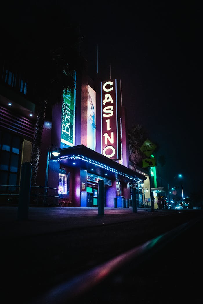 A well-lit casino exterior with glowing neon signs and vibrant colors captured at night.